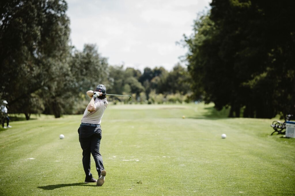 A golfer swings on a bright day in Bogotá, Colombia's lush green golf course.